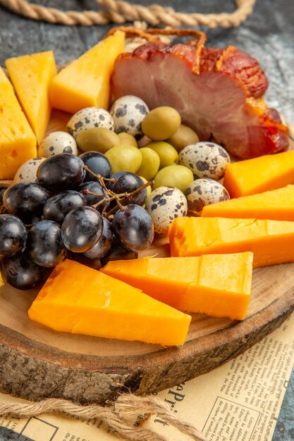 Hochauflösendes Foto des besten Snacks mit verschiedenen Früchten und Lebensmitteln auf einem hölzernen braunen Tablettseil auf einer alten Zeitung