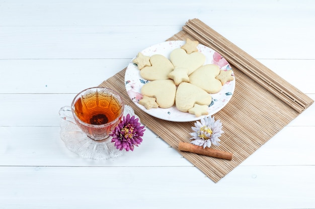 Kostenloses Foto hochwinkelansicht herzförmig und sternplätzchen, blumen im tischset mit zimt