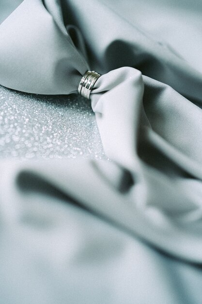 Hochwinkelansicht-Hochzeitsdekoration mit grauem Stoff auf grauem strukturiertem Hintergrund. Vertikale