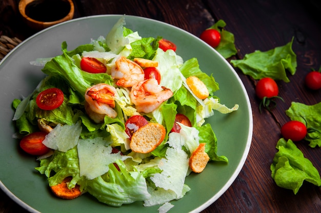 Hochwinkelansicht köstlicher Salat in Platte auf hölzernem Hintergrund.