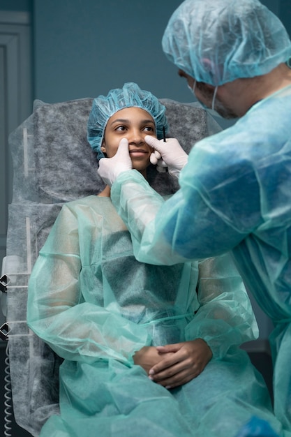 Hochwinkelarzt, der den Patienten vor der Rhinoplastik untersucht