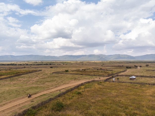 Hochwinkelaufnahme der Bauernhöfe mit den Bergen im Hintergrund, die in Samburu, Kenia gefangen genommen werden