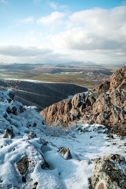 Hochwinkelaufnahme der hohen Berge, die tagsüber mit wenig Schnee bedeckt sind