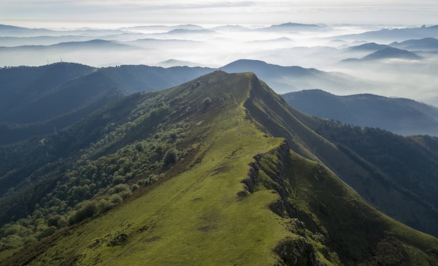 Kostenloses Foto hochwinkelaufnahme einer wunderschönen berglandschaft mit hügeln unter einem bewölkten himmel