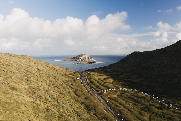 Hochwinkelaufnahme eines Gebirgstals mit einer kleinen Insel im offenen Meer