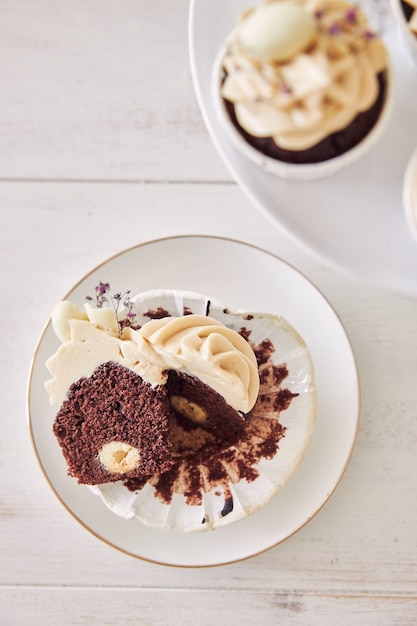 Hochwinkelaufnahme eines köstlichen Schokoladen-Cupcakes mit weißem Sahnebelag