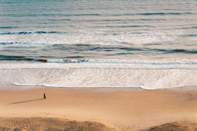 Hochwinkelaufnahme eines schönen gewellten Ozeans gegen einen braunen Sand