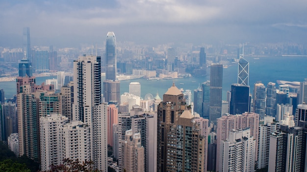 Hochwinkelaufnahme eines Stadtbildes mit vielen hohen Wolkenkratzern unter dem bewölkten Himmel in Hong Kong