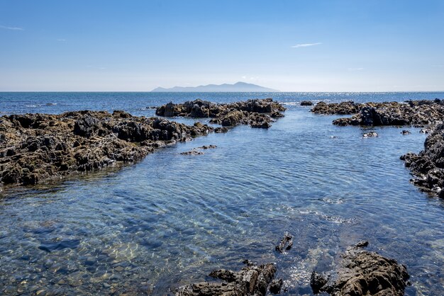 Hochwinkelaufnahme von Felsformationen im Wasser der Pukerua Bay in Neuseeland