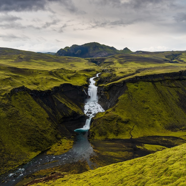 Hochwinkelaufnahme von Wasserfällen in der Hochlandregion von Island mit einem bewölkten grauen Himmel