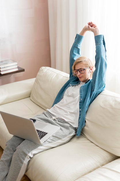 Hochwinkelfrau, die am Laptop arbeitet und sich streckt