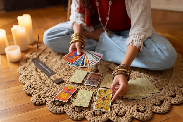 Kostenloses Foto hochwinkelige frau, die zu hause tarot liest