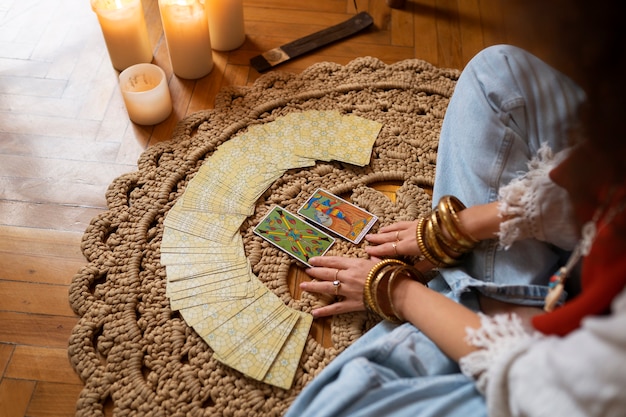 Kostenloses Foto hochwinkelige frau, die zu hause tarot liest