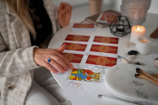 Kostenloses Foto hochwinkelige frau, die zu hause tarot liest