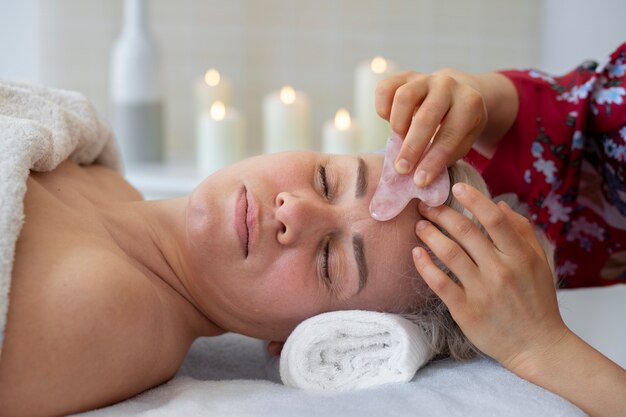 Hochwinkelige Hand mit Gua Sha für die Gesichtsmassage