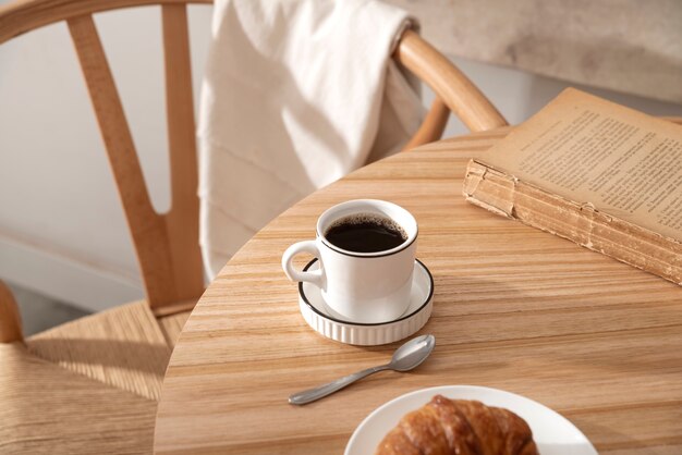 Hochwinkelige Kaffeetasse und Buch auf dem Tisch