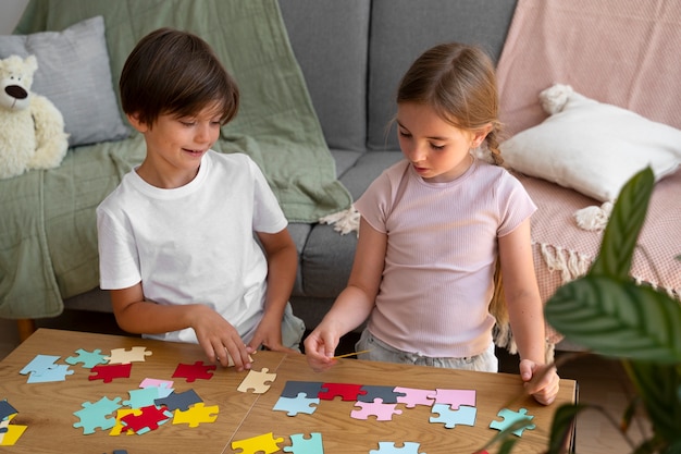 Hochwinkelige Kinder, die zusammen ein Puzzle machen