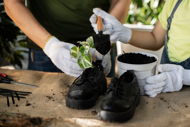 Hochwinkelige Leute, die mit alten Schuhen im Garten arbeiten