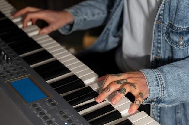 Kostenloses Foto hochwinkeliger mann, der im studio klavier spielt