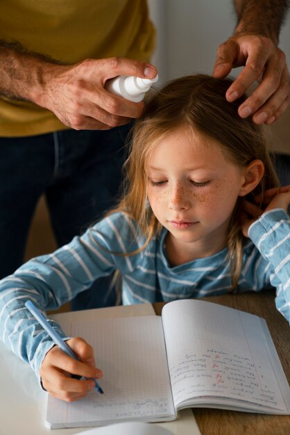 Hochwinkeliger Vater mit Läusebehandlung