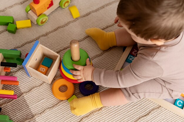 Hochwinkeliges Kind, das mit bunten Spielsachen spielt