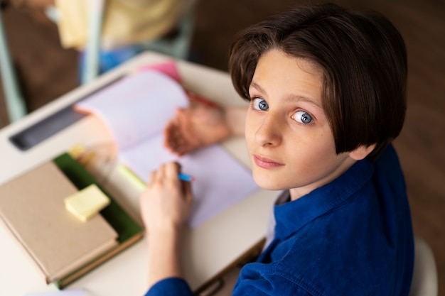 Kostenloses Foto hochwinkelkind, das in der schule betrügt