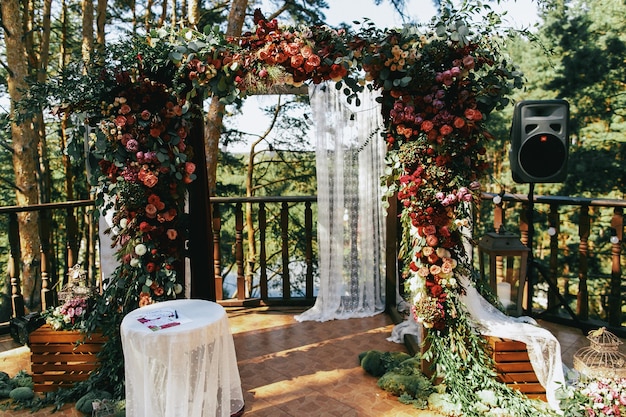 Hochzeitsaltar gemacht vom bunten Speerworts und vom weißen Vorhang