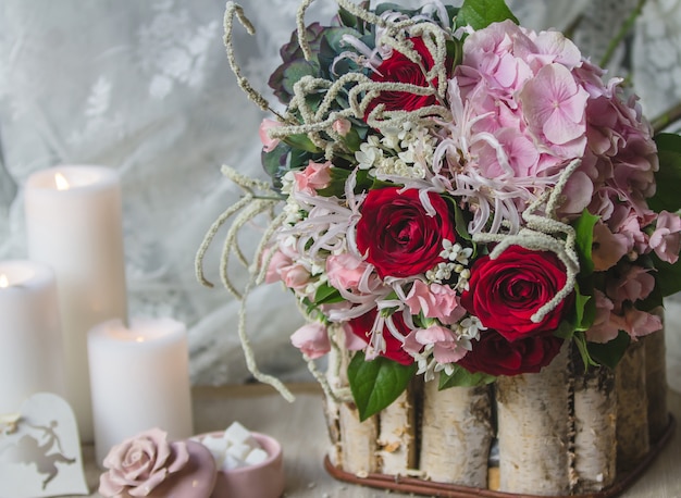 Hochzeitsblumenstrauß in einem hölzernen Stück mit weißen Kerzen