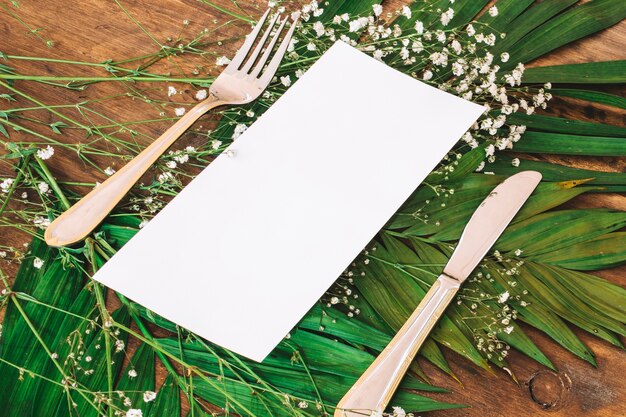 Hochzeitsmenükonzept mit Tischbesteck auf Blättern