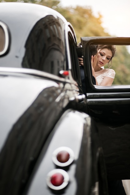 Hochzeitspaar-Fotoaufnahme durch Retro- Auto