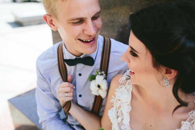 Hochzeitspaar sitzt auf einer Steinbank, Nahansicht