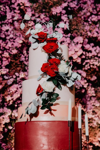 Hochzeitstorte mit roten Rosen geschmückt