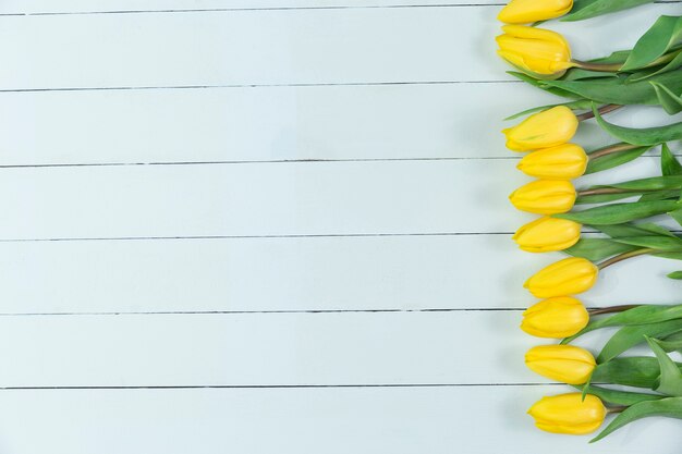Hölzerne Oberfläche mit gelben Tulpen