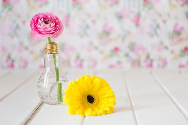 Hölzerne Oberfläche mit rosa und gelben Blumen