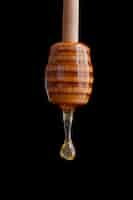 Kostenloses Foto hölzerner honigschöpflöffel mit tropfendem honig