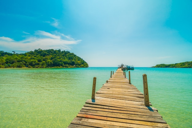 Hölzerner Pier oder Brücke mit tropischem Strand und Meer in der Paradiesinsel