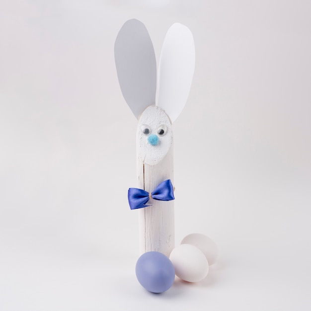 Kostenloses Foto hölzernes kaninchen mit den papierohren und ostereiern
