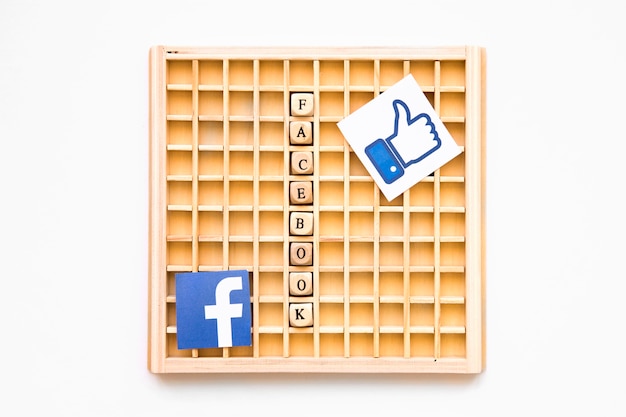 Hölzernes Scrabblespiel mit ähnlichem Symbol, Facebook-Wort und Ikone