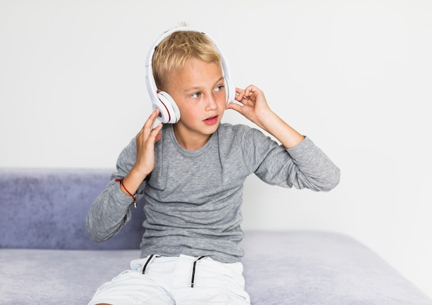 Kostenloses Foto hörende musik des kleinen jungen zu hause