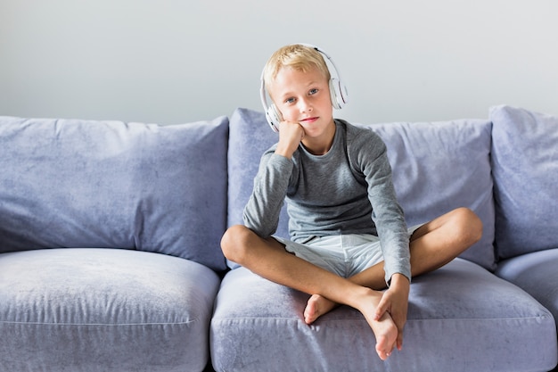 Kostenloses Foto hörende musik des kleinen jungen zu hause