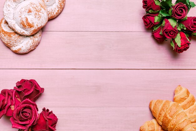 Hörnchen mit Blumenstrauß und Brötchen der roten Rosen