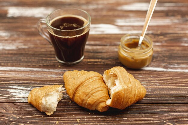 Hörnchen mit Kaffeetasse und Erdnussbutter auf dem Tisch