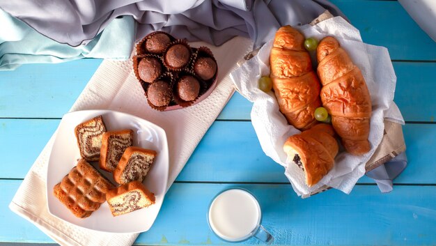 Hörnchen, Schokoladenpralinen und Vanilletorte auf der blauen Tabelle.