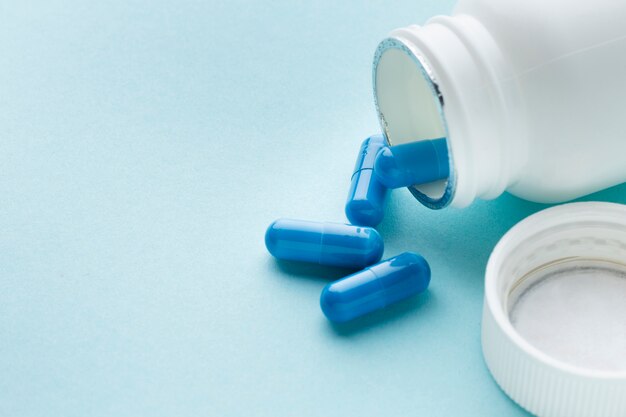 Hohe Ansicht blaue Pillen verschüttet vom Behälter
