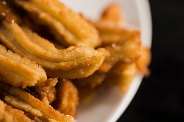 Hohe Ansicht gebratene Churros auf einer Platte