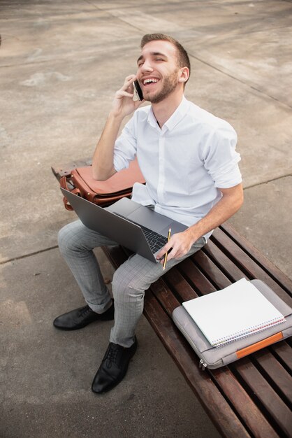 Hohe Ansicht schoss vom Hochschulstudenten, der am Telefon spricht