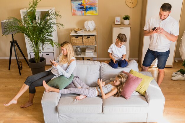 Hohe Ansichtfamilie, die ihre Zeit am Handy verbringt