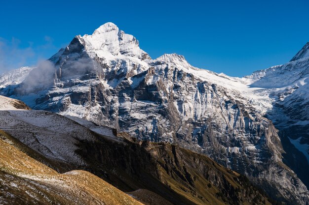 Hohe felsige Berge mit Schnee bedeckt unter einem klaren blauen Himmel in der Schweiz