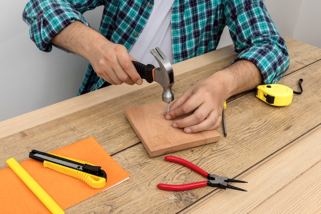 Hohe Sicht Hände mit Hammer und Nägeln