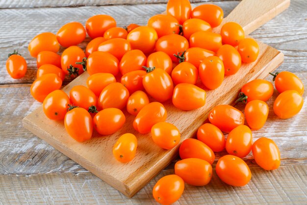 Hohe Winkelansicht der Mini-Tomaten auf Holz und Schneidebrett